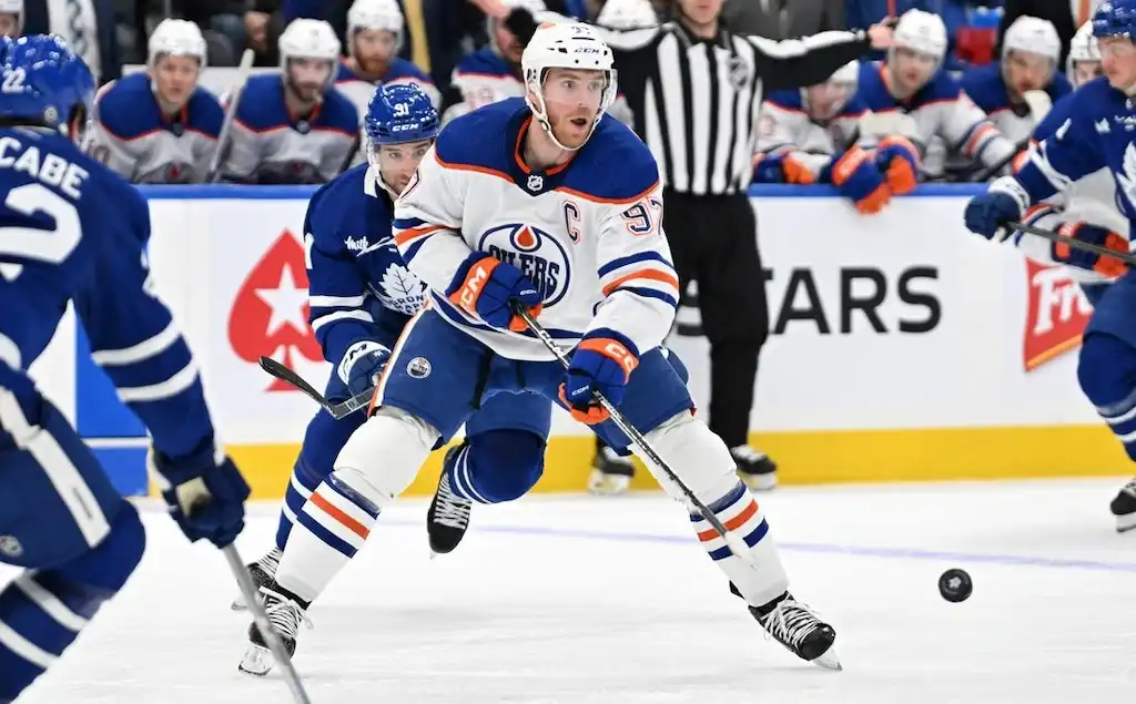 NHL 2 Edmonton Oilers captain, skates toward the puck during a game against the Toronto Maple Leafs.