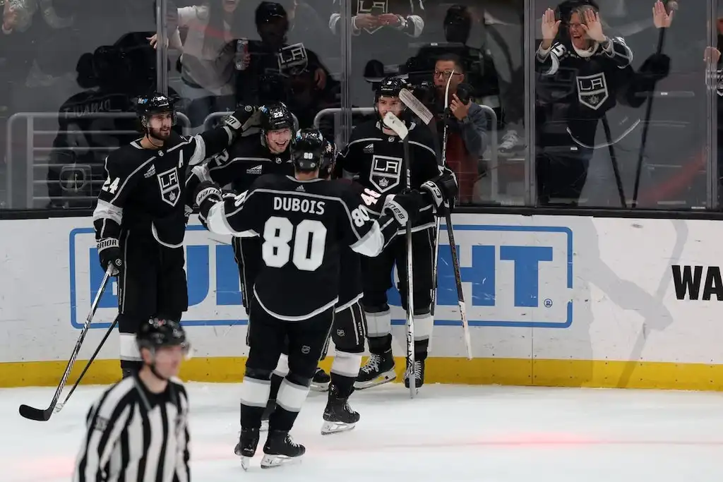 LA Kings hockey players celebrate near the glass.