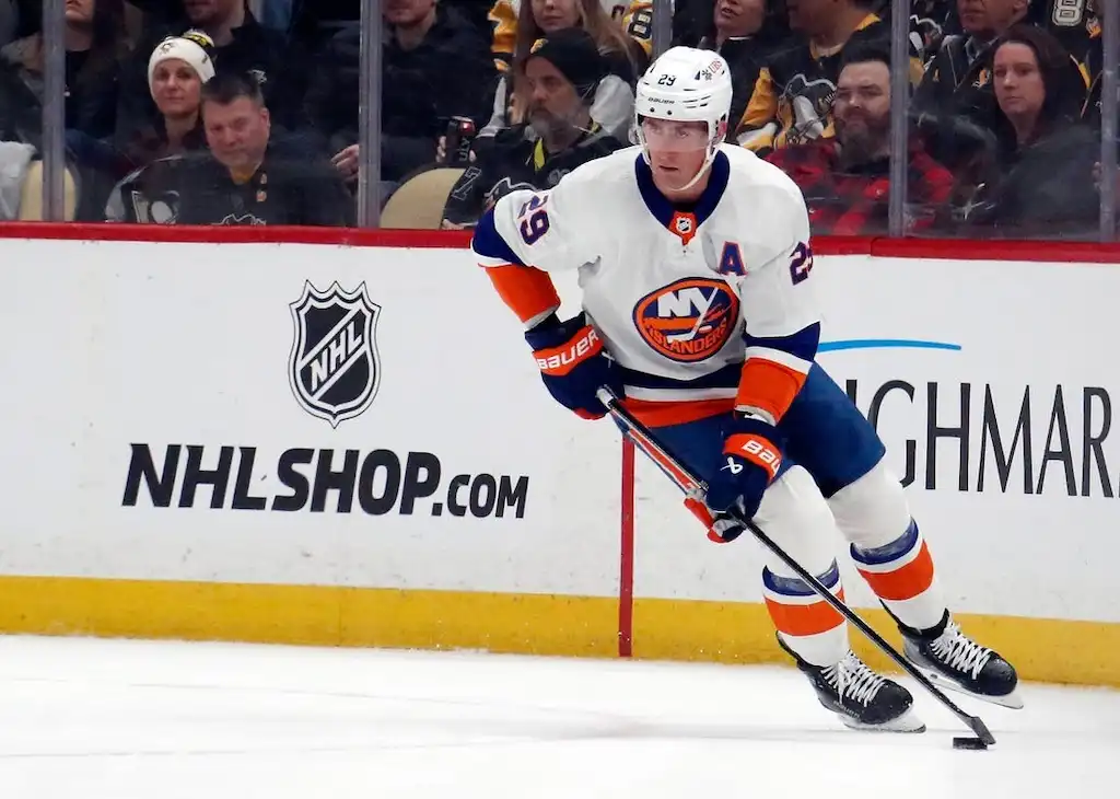 New York Islanders captain skates along the boards.
