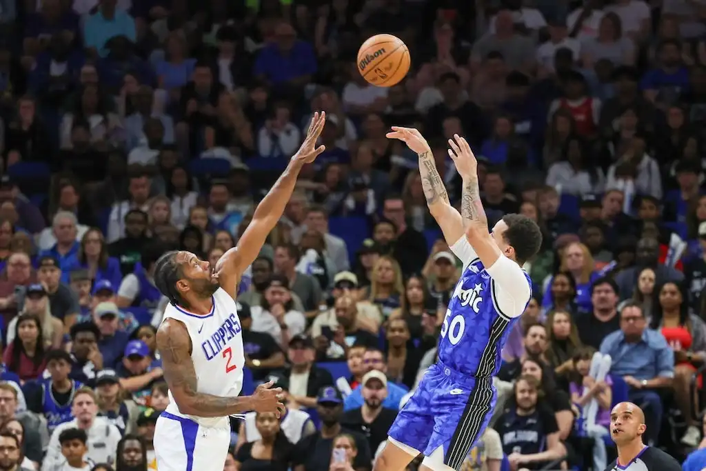 An Orlando Magic player releases a jump shot over a defender from the LA. Clippers.