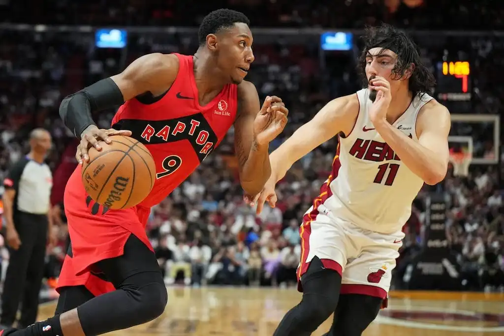 10 A Toronto Raptors player drives to the basket while being closely guarded by a Miami Heat defender.