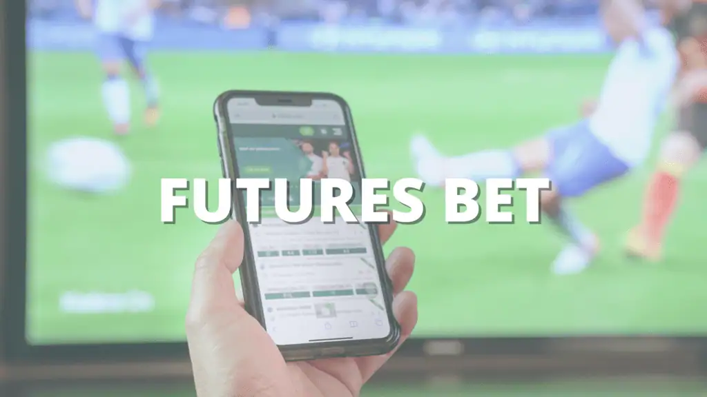 Hand holding a smartphone with a betting app in front of a soccer match on TV, with text reading "Futures Bet."