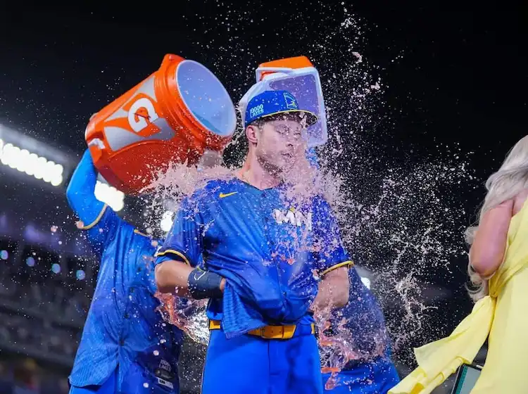 A Minnesota Twins player gets drenched with pink sports drink from coolers in a celebratory.