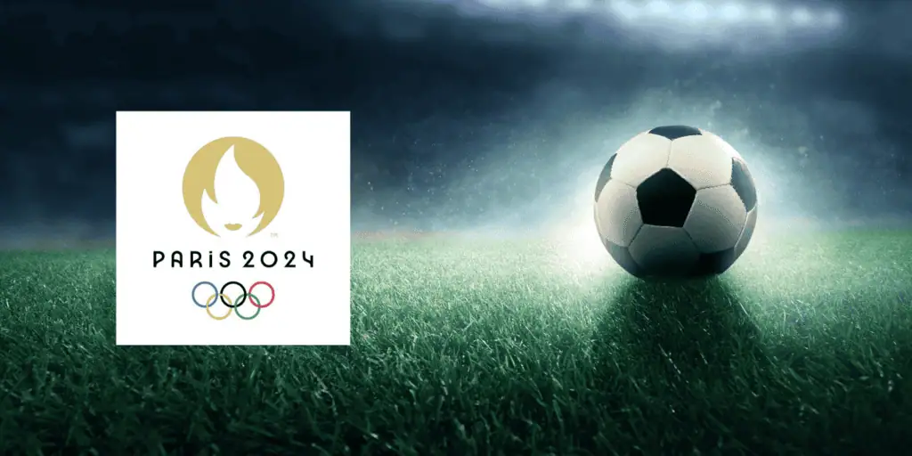A soccer ball on a grassy field illuminated by stadium lights, alongside the Paris 2024 Olympics logo.