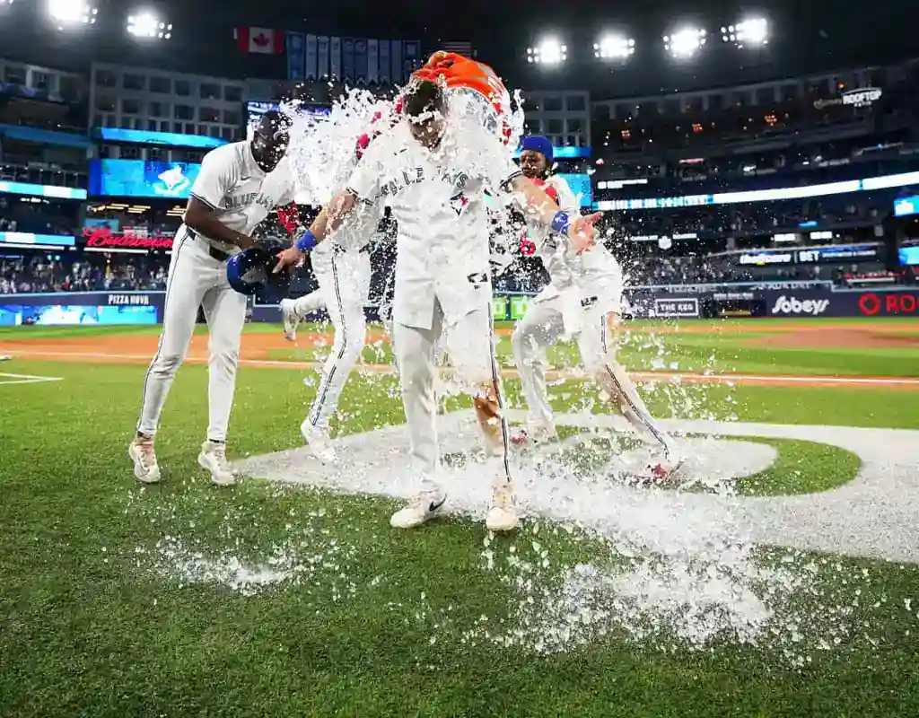 Toronto Blue Jays players celebrate with water splash after game win against Oakland Athletics