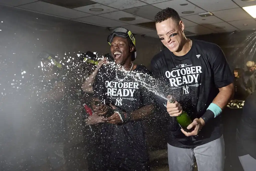 New York Yankees players celebrate in the locker room by spraying champagne.