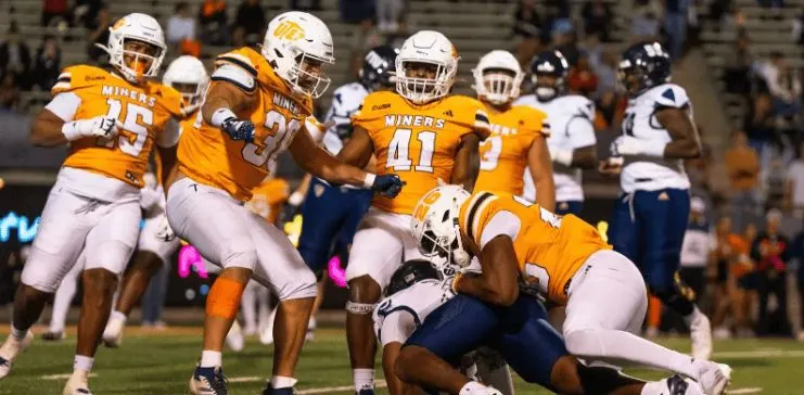 ncaaf players blocking a rival team player