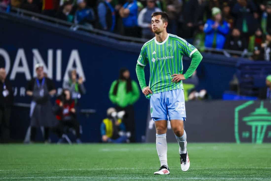 Green uniform player standing in the middle of the pitch