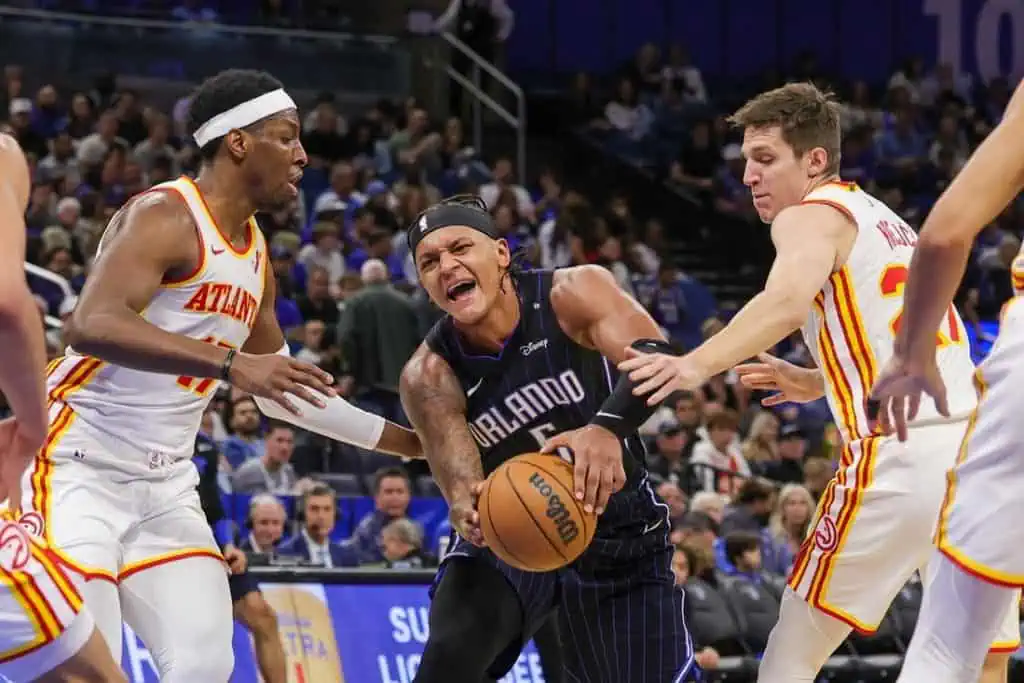 An Orlando player struggles for control of the basketball amid defensive pressure from two Atlanta players during a game.