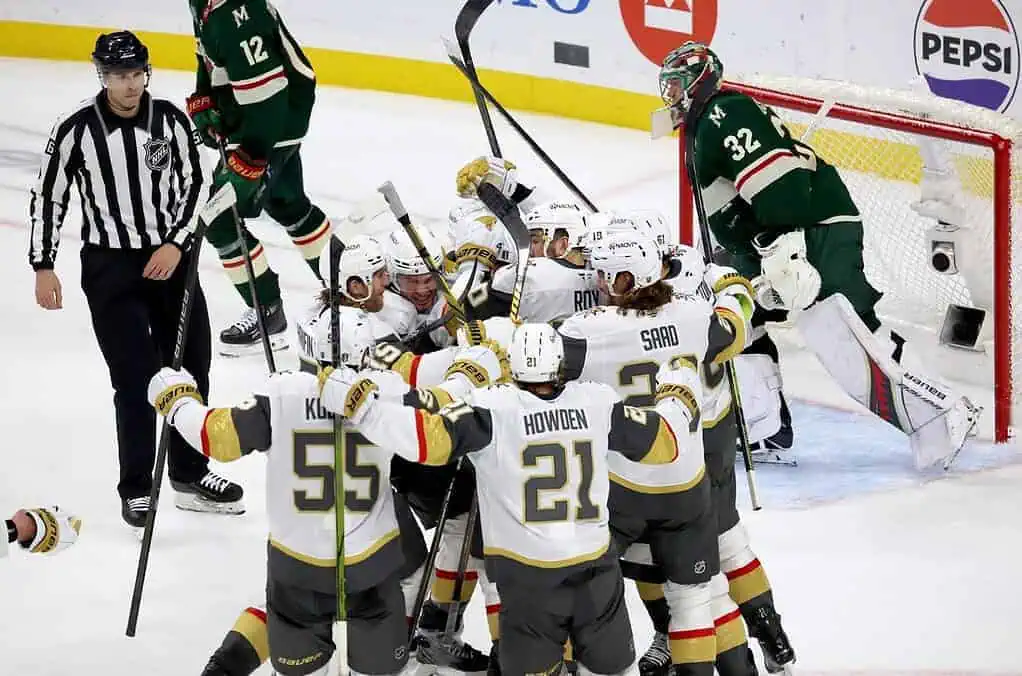 NHL 2 Hockey players celebrate a goal, surrounded by teammates, with an official nearby and a goaltender watching from the crease.
