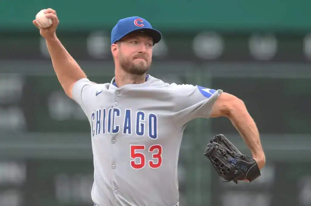 A Chicago Cubs pitcher in a gray jersey with the number 53 prepares to throw a baseball, showcasing a focused windup.