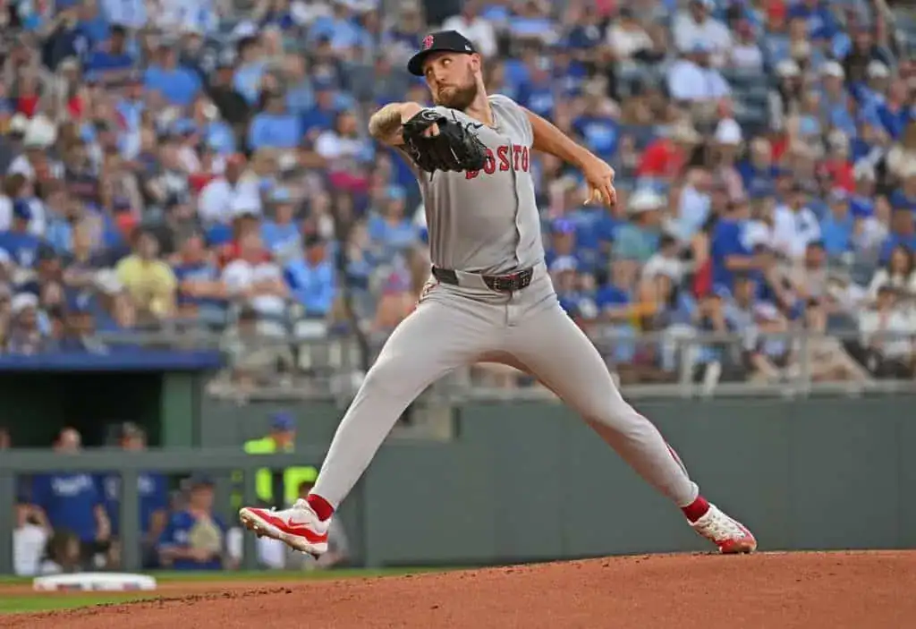2 A Boston Red Sox pitcher in mid-throw on a baseball mound, with a crowd of fans in the background at a sunny game.