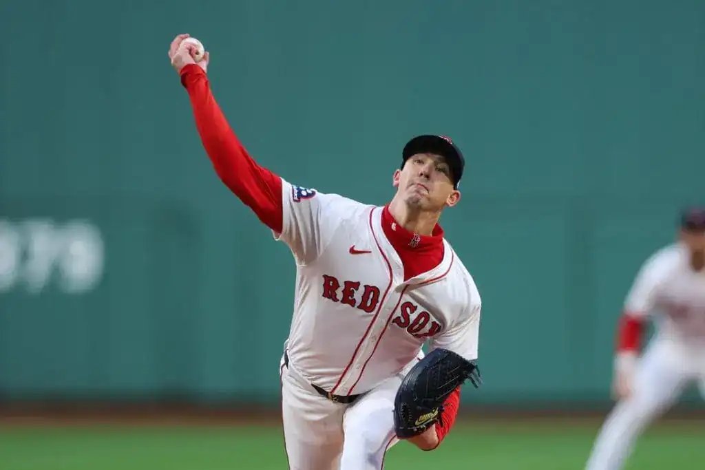 4 A Red Sox pitcher winds up to throw a pitch on the baseball mound, showcasing focused athleticism in a stadium setting.