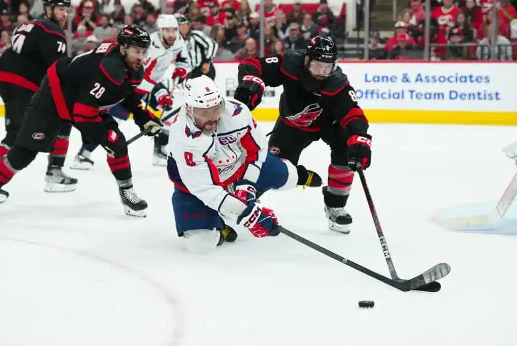 A tense moment in a hockey game where players scramble for the puck on the ice, showcasing action and competitive spirit.
