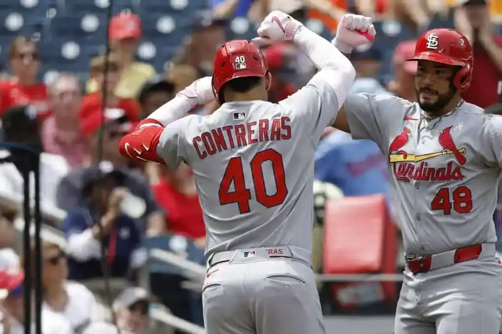 8 A St. Louis Cardinals player celebrates with teammates after a successful play, wearing a gray jersey with "CONTRERAS" and number 40.