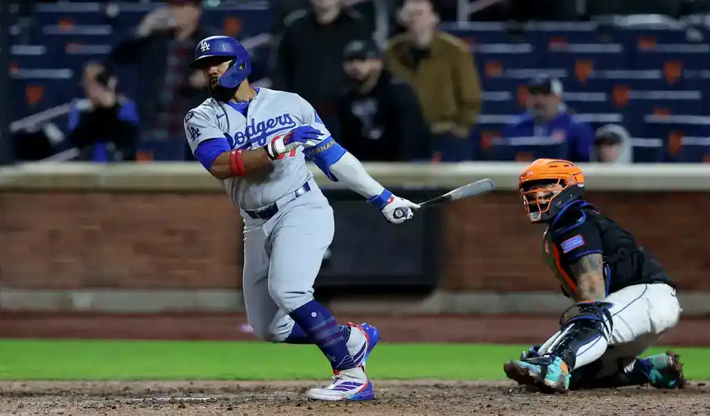 8 Los Angeles Dodgers batter follows through on swing as New York Mets catcher watches during May 24, 2025 game.