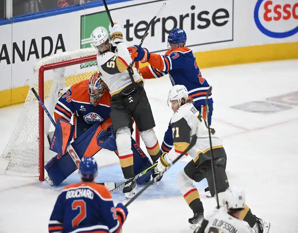 NHL playoff game between the Vegas Golden Knights and Edmonton Oilers with players battling in front of the net during a high-intensity moment.