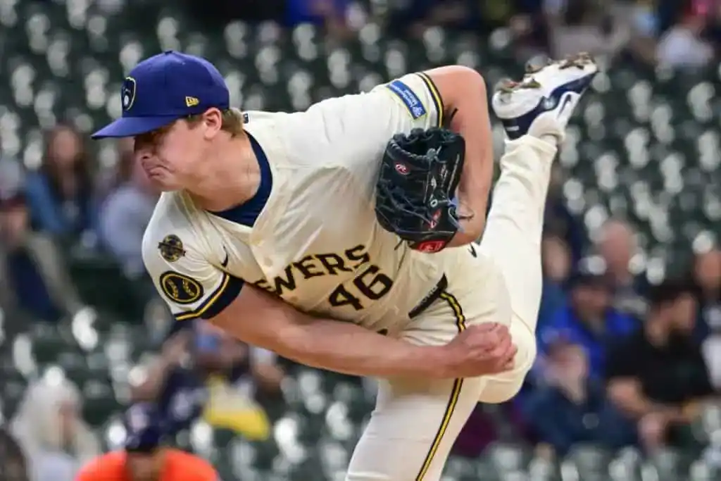 A pitcher in a Brewers jersey delivers a fastball during a baseball game,