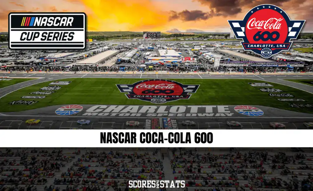 Aerial view of Charlotte Motor Speedway during the NASCAR Coca-Cola 600 with colorful banners and excited crowds at sunset.