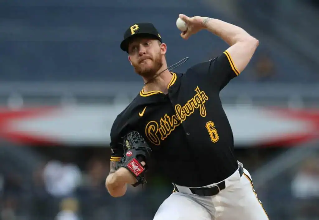 5 A baseball player in a black Pittsburgh Pirates jersey winds up to pitch, showcasing athletic form in a stadium setting.