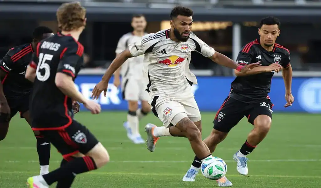 New York Red Bulls player dribbles past Atlanta United defenders during match