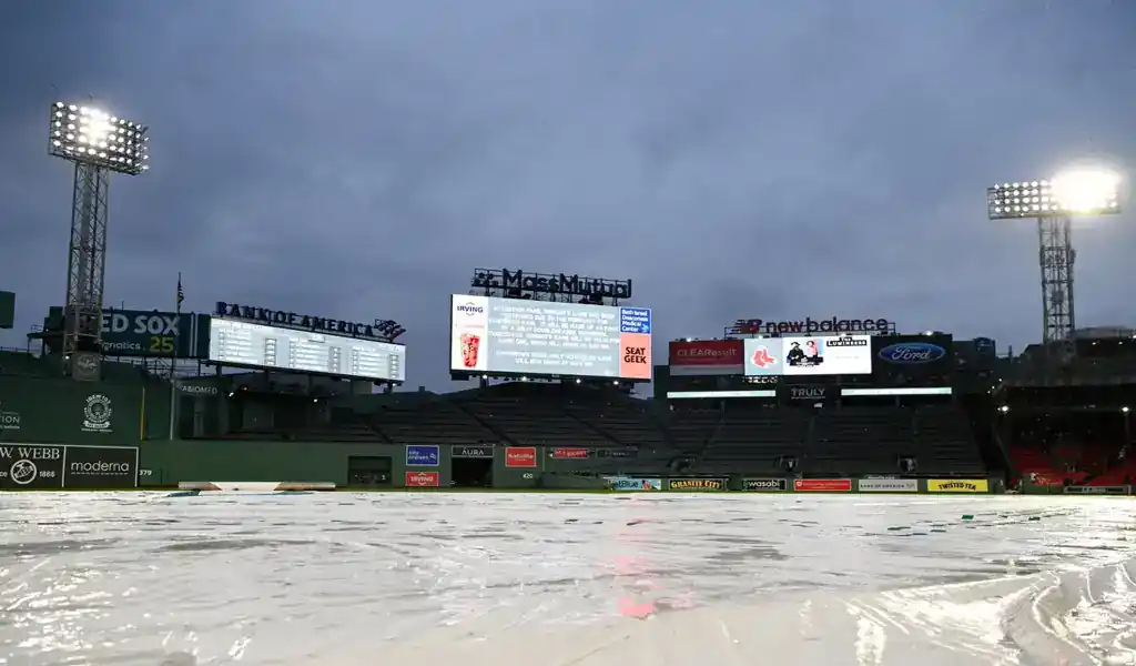 9 Fenway Park scoreboard and tarp-covered field during rain delay before Boston Red Sox vs Baltimore Orioles game on May 24, 2025.