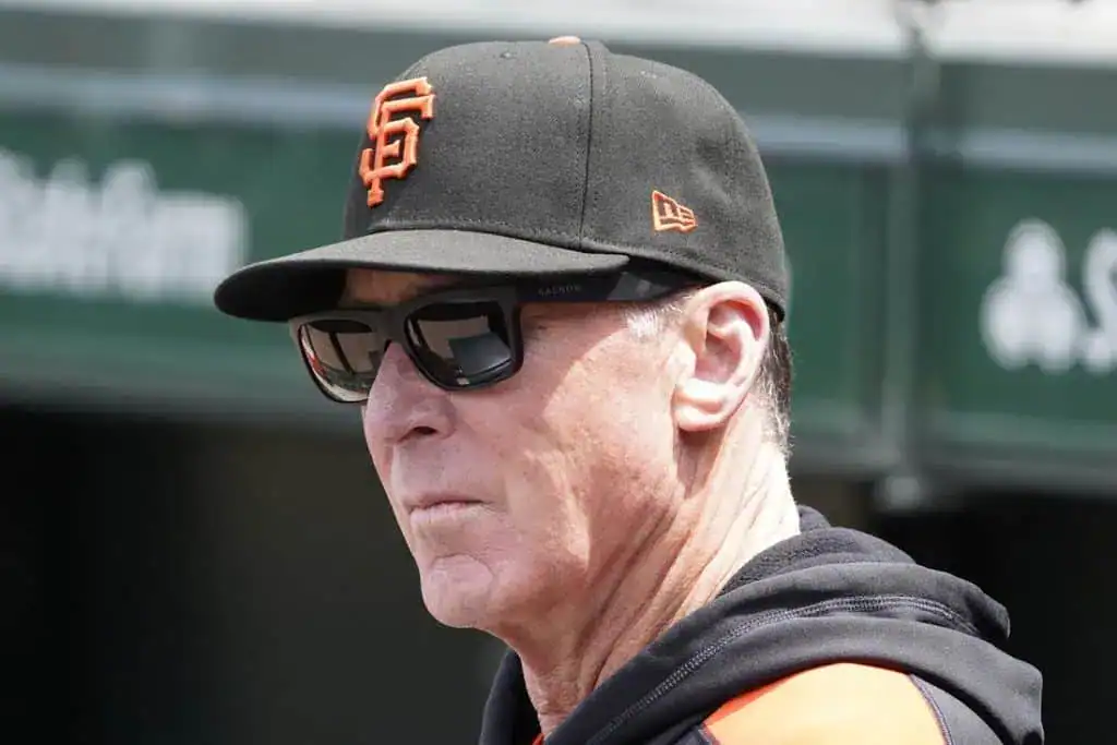 8 A person wearing a black San Francisco Giants cap and jacket stands outdoors, with a baseball stadium backdrop visible.