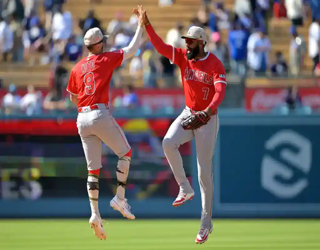 9 Los Angeles Angels players celebrate with a high-five during a game against the Oakland Athletics on May 19, 2025