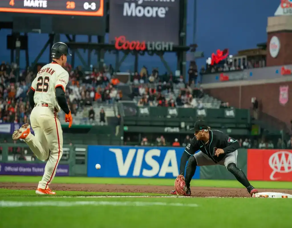 4 Arizona Diamondbacks first baseman stretches for throw as San Francisco Giants runner approaches during May 13, 2025 MLB game