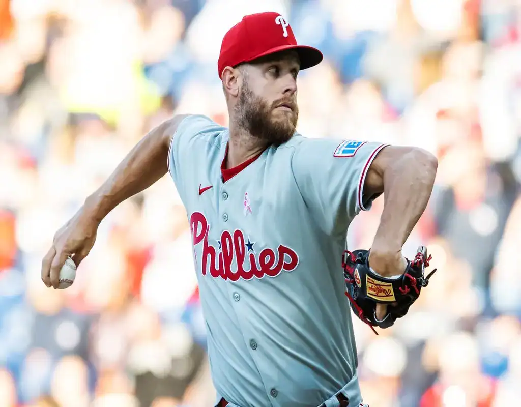 Philadelphia Phillies pitcher winding up for a pitch with a blurred stadium crowd in the background