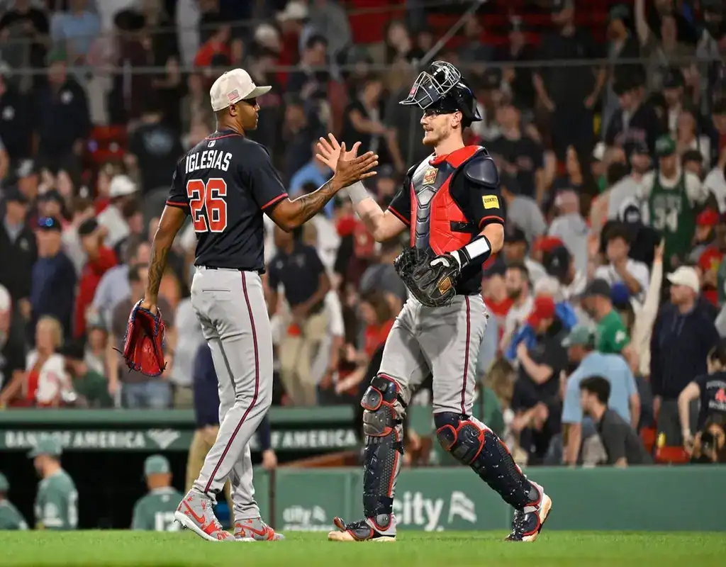 6 Boston Red Sox reliever #26 Iglesias and the catcher exchanging a high-five on the mound behind home plate in a packed stadium