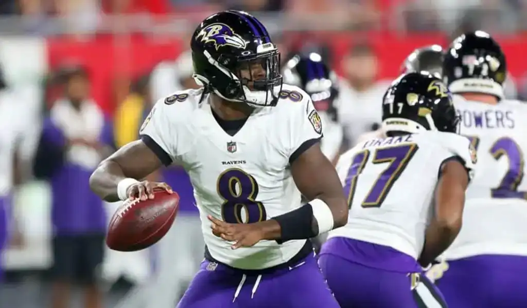 Jugador de los Baltimore Ravens preparándose para lanzar el balón durante un partido, representando la AFC Norte para la temporada NFL 2024-25.