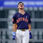A baseball player in an Astros uniform walks confidently on the field, showcasing determination and focus during a game.
