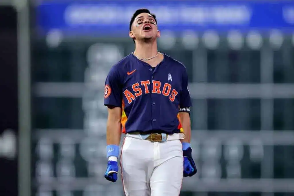 A baseball player in an Astros uniform walks confidently on the field, showcasing determination and focus during a game.
