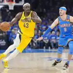 A basketball player in a yellow Indiana jersey dribbles past an opponent in a blue Oklahoma City Thunder uniform during a game.