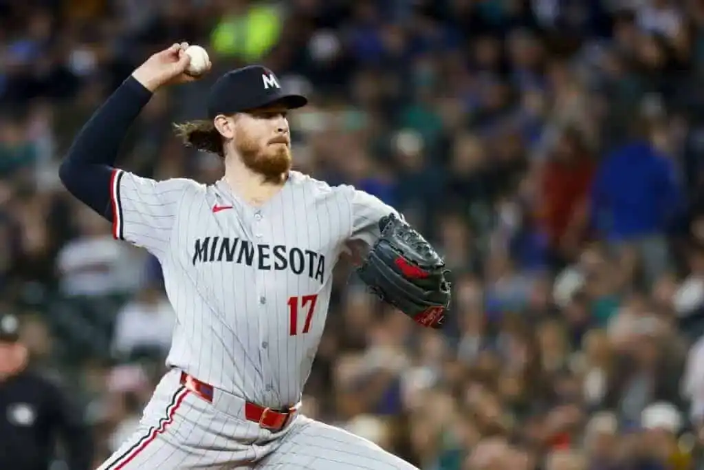 A pitcher in a Minnesota Twins uniform throws a baseball amid a packed stadium, showcasing intense focus and athleticism.