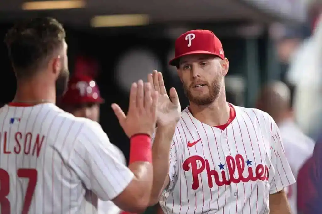 Two Philadelphia Phillies players celebrate with high fives in a dugout, showcasing their team spirit and camaraderie.