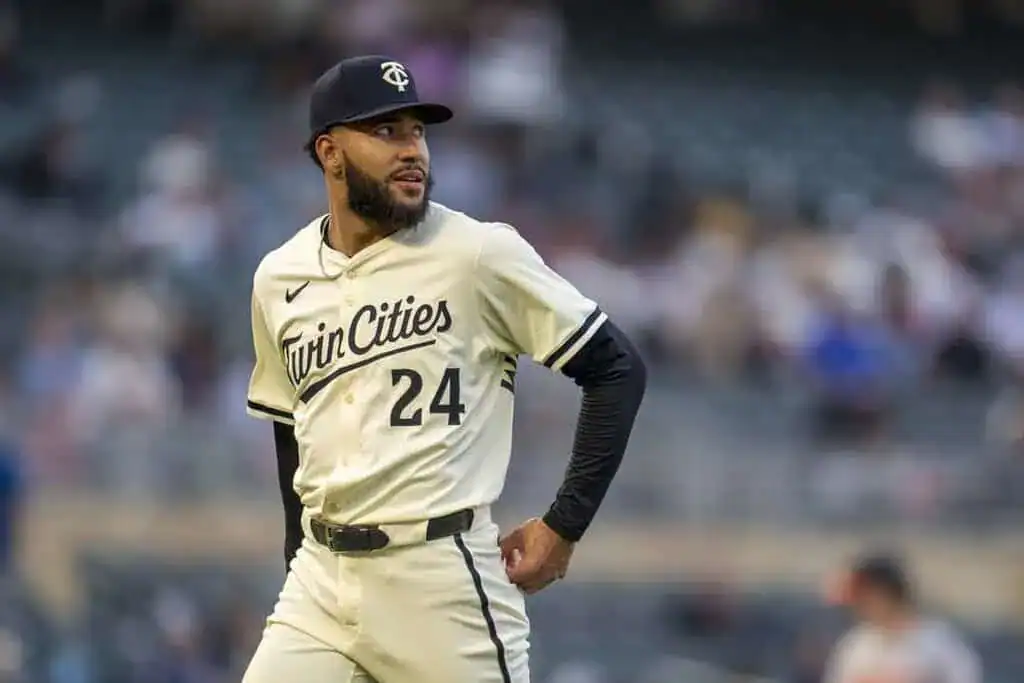 A player in a white baseball jersey with "Twin Cities" and the number 24 walks on the field during a game, with spectators in the background.